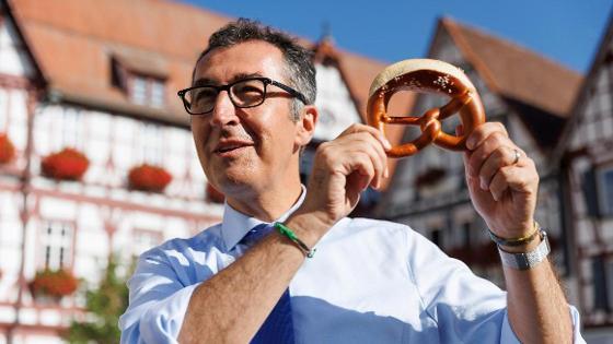 Bundesminister Özdemir hält eine Brezel in die Höhe.