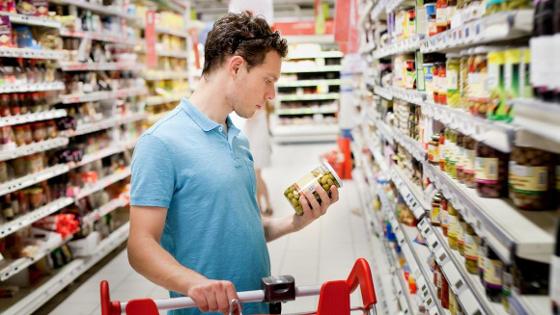Ein Verbraucher betrachtet im Supermarkt ein Produkt
