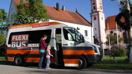 Eine Mutter mit ihrer kleinen Tochter steigen in den Flexibus