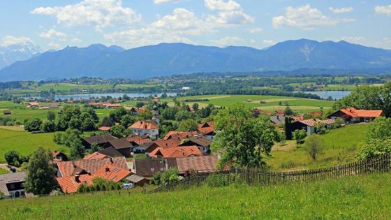 ein Dorf - im HIntergrund ein See und Berge