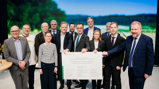 Gruppenfoto: Bundesminister Özdemir und die Wertschöpfungskette Backweizen halten die Erklärung in die Höhe