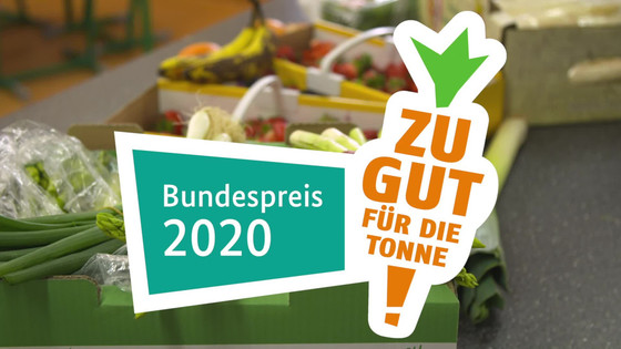 im Vordergrund der Schriftzug "Zu gut für die Tonne" Bundespreis 2020, im Hintergrund Kisten mit Obst und Gemüse