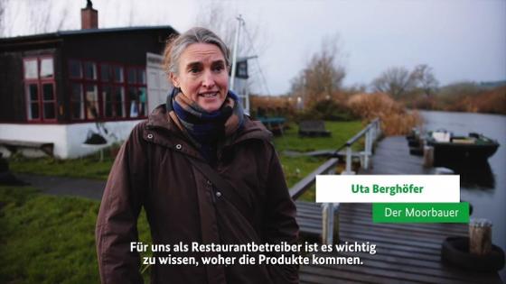 Eine Frau steht am Rande eines Flusses vor einem Restaurant. Eine Frau steht am Rande eines Flusses vor einem Restaurant.