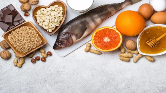 Übersicht von häufig Allergie-auslösenden Lebensmitteln: Fisch, Nüsse, Schokolade, Eier, Honig, Obst, Getreide