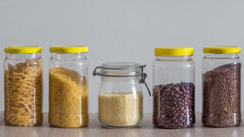 Glasbehälter mit trockenen Lebensmitteln wie Bohnen, Linsen, Nudeln