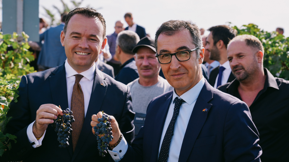 Bundesminister Cem Özdemir mit seinem mazedonischen Kollegen Faton Peci, beide halten eine Rebe in der Hand