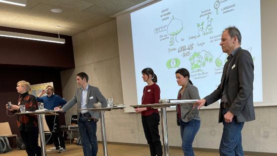 Die Teilnehmer der Podiumsdiskussion stehen auf der Bühne. Die Teilnehmer der Podiumsdiskussion stehen auf der Bühne.