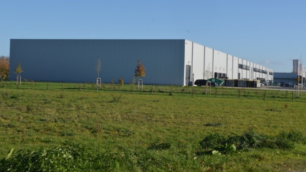 Blick über den Acker auf ein neu gebautes Logistikzentrum Blick über den Acker auf ein neu gebautes Logistikzentrum