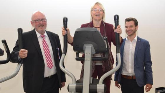 Gruppenfoto mit Ministerin Alheit auf einem Fitnessgerät.