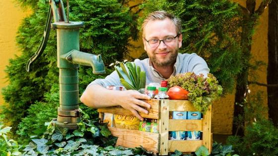 Ein Mann mit einer Holzkiste, dem sog. "Arnstorfer Kisterl", mit der Corona-Betroffene Lebensmittel erhalten.